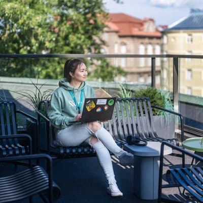 Mehiläisen digipalveluiden työntekijä istuu Kampin terassin parvekkeella ja katsoo maisemia.