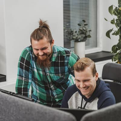 Mehiläisen digitaalisten palveluiden työntekijät tekevät töitä yhdessä iloisina.