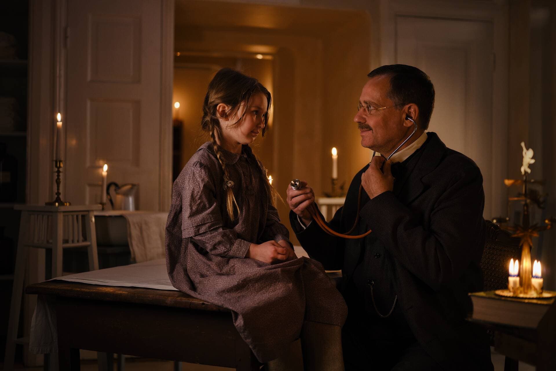 A Mehiläinen doctor examines a child patient with a stethoscope. The picture is styled to evoke the old Christmas atmosphere of 1909.