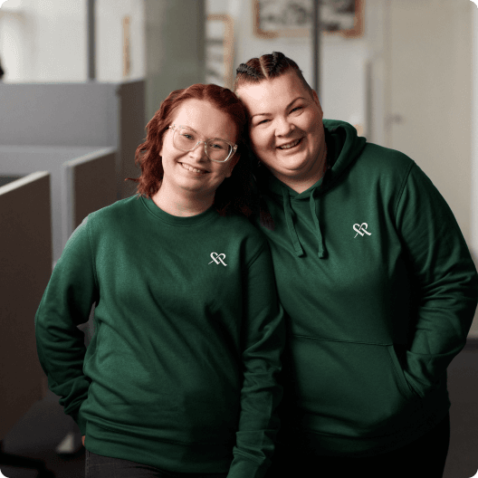 Two women at work, wearing Mehiläinen's hoodies