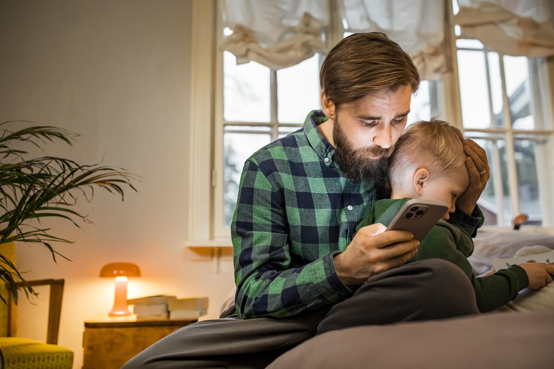Isä lohduttaa sylissään olevaa lasta.