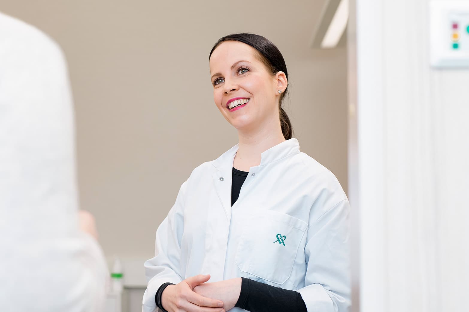 En gynekolog, det vill säga en specialistläkare inom kvinnosjukdomar och förlossningar ler mot en kund.