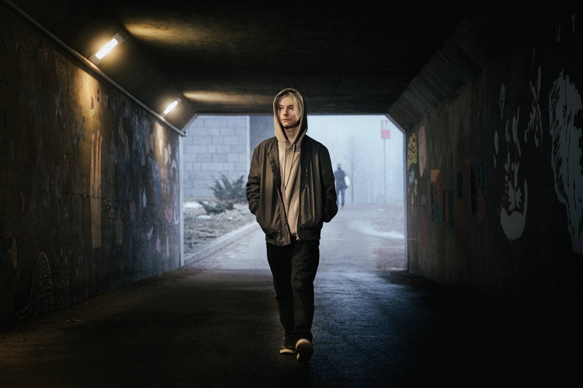 Poika kävelee yksin tunnelissa.