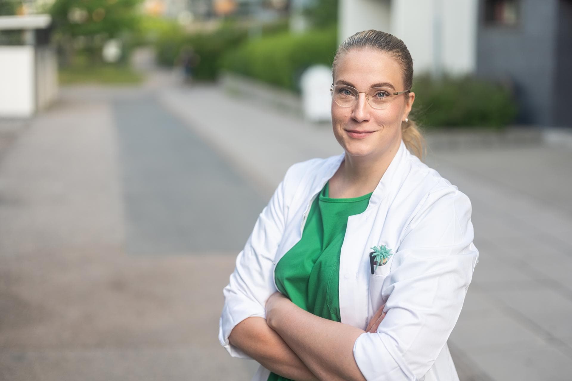Mehiläisen keuhkosairauksien erikoislääkäri eli keuhkolääkäri seisoo lääkärin takissa ulkona.