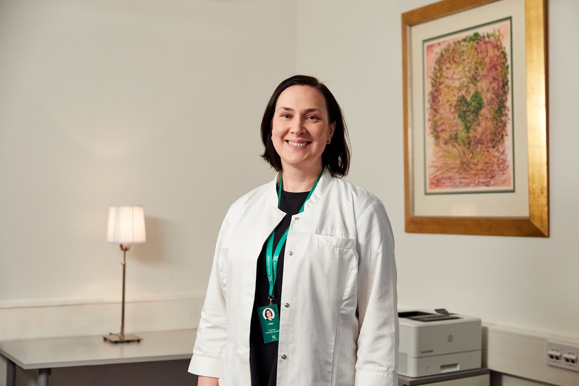 Mehiläisen gynekologi hymyilee ja katsoo kameraan