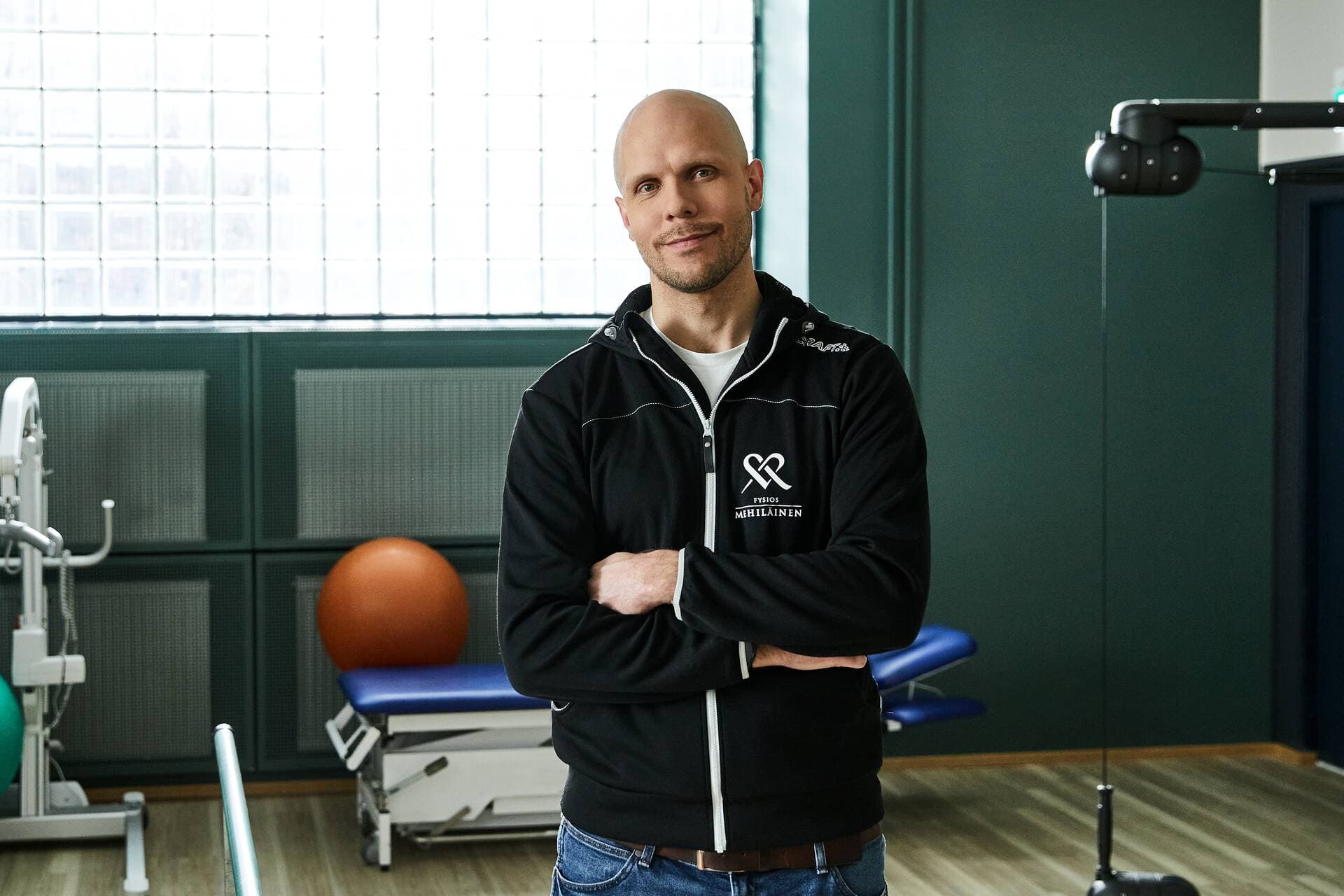 Mehiläinens fysioterapeut och terapeutiska träningsredskap i bakgrunden.
