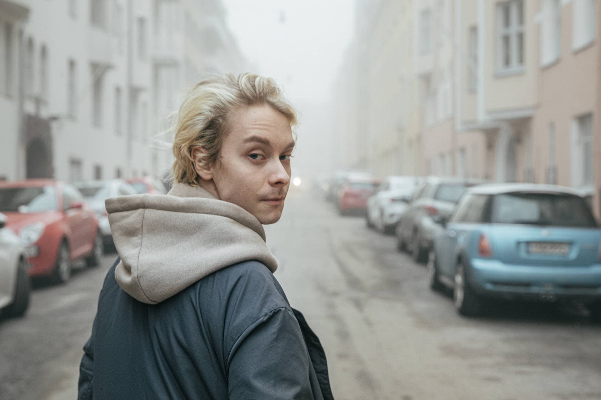 Henkilö kävelee sumuisessa kaupungissa.