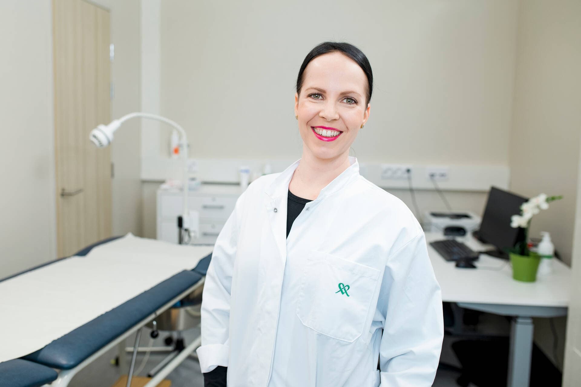 Mehiläisen gynekologi hymyilee vastaanottohuoneessa.