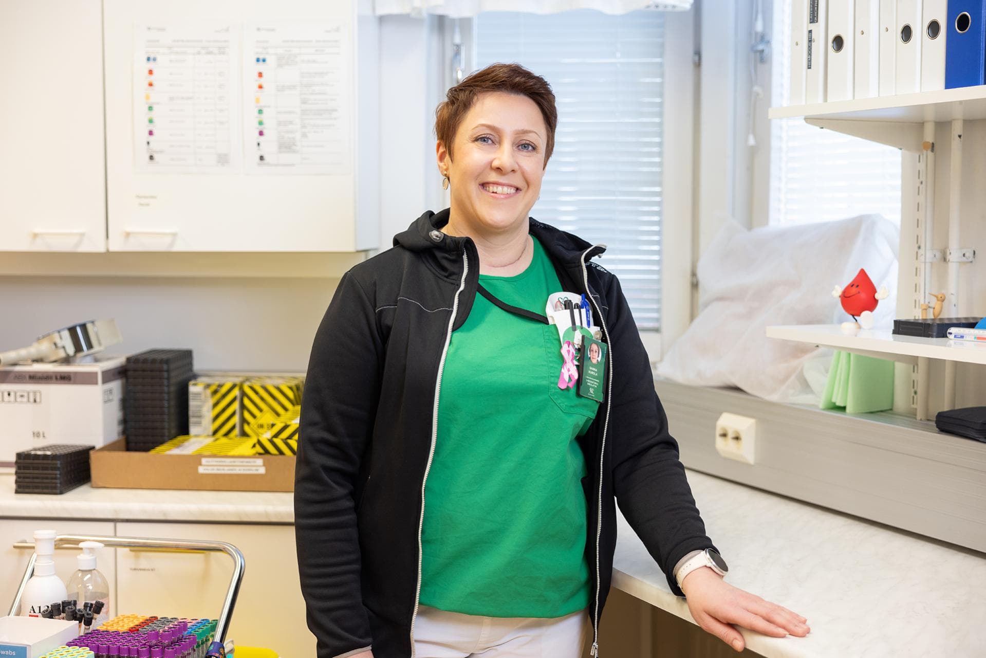 Mehiläisen laboratoriotyöntekijä Sanna seisoo iloisena laboratoriossa.