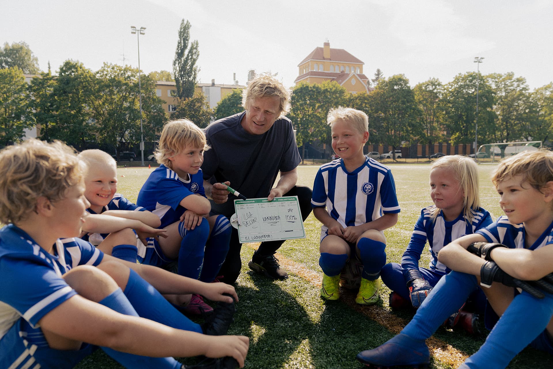 Valmentaja kannustaa joukkuetta jalkapallokentällä.