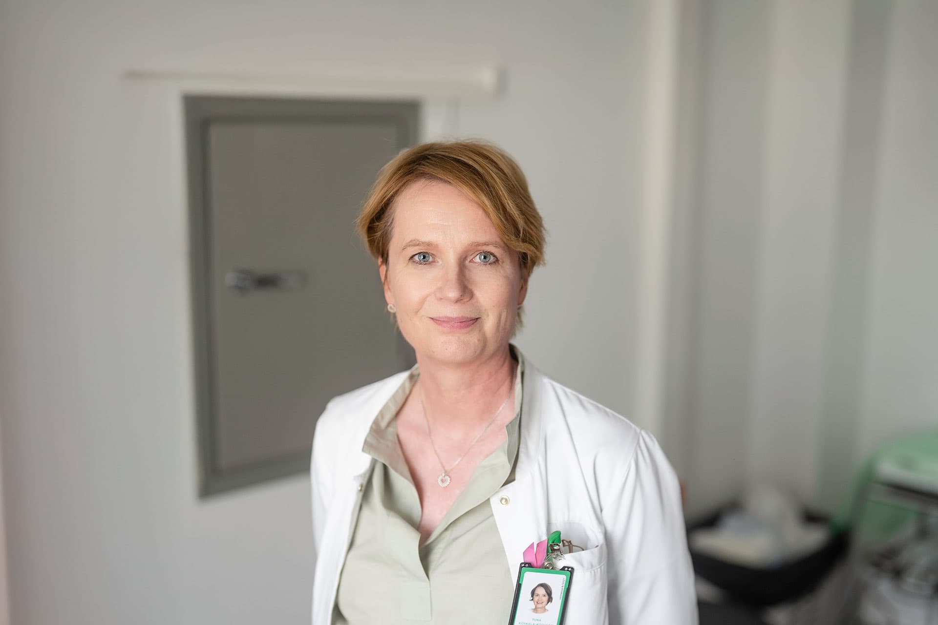 Mehiläinens läkare Tiina ler mot kameran i mottagningsrummet.