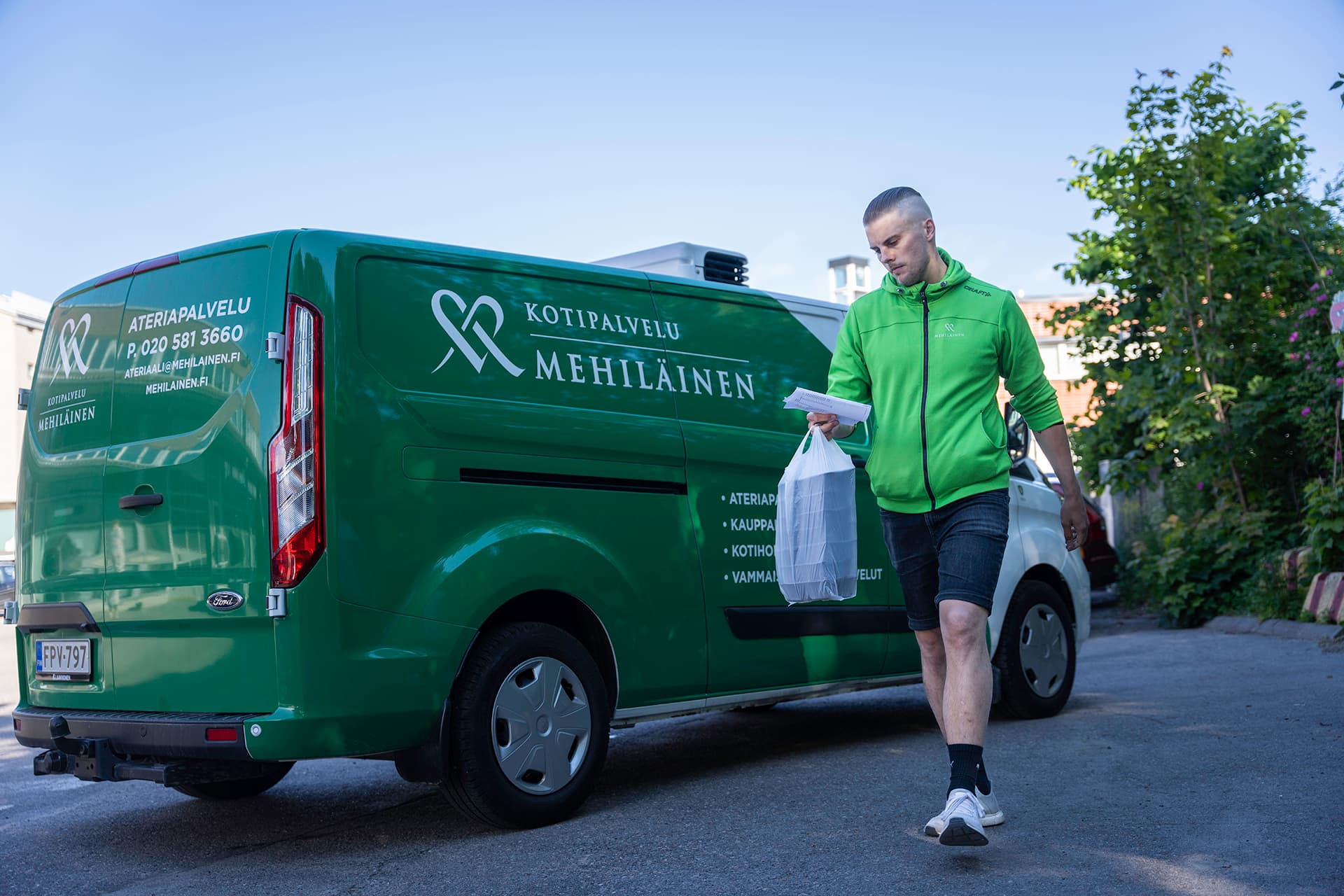 Mehiläinen Kotipalveluiden Kauppakassipalvelun kuljettajalla kantamassa ostoksia autoon.