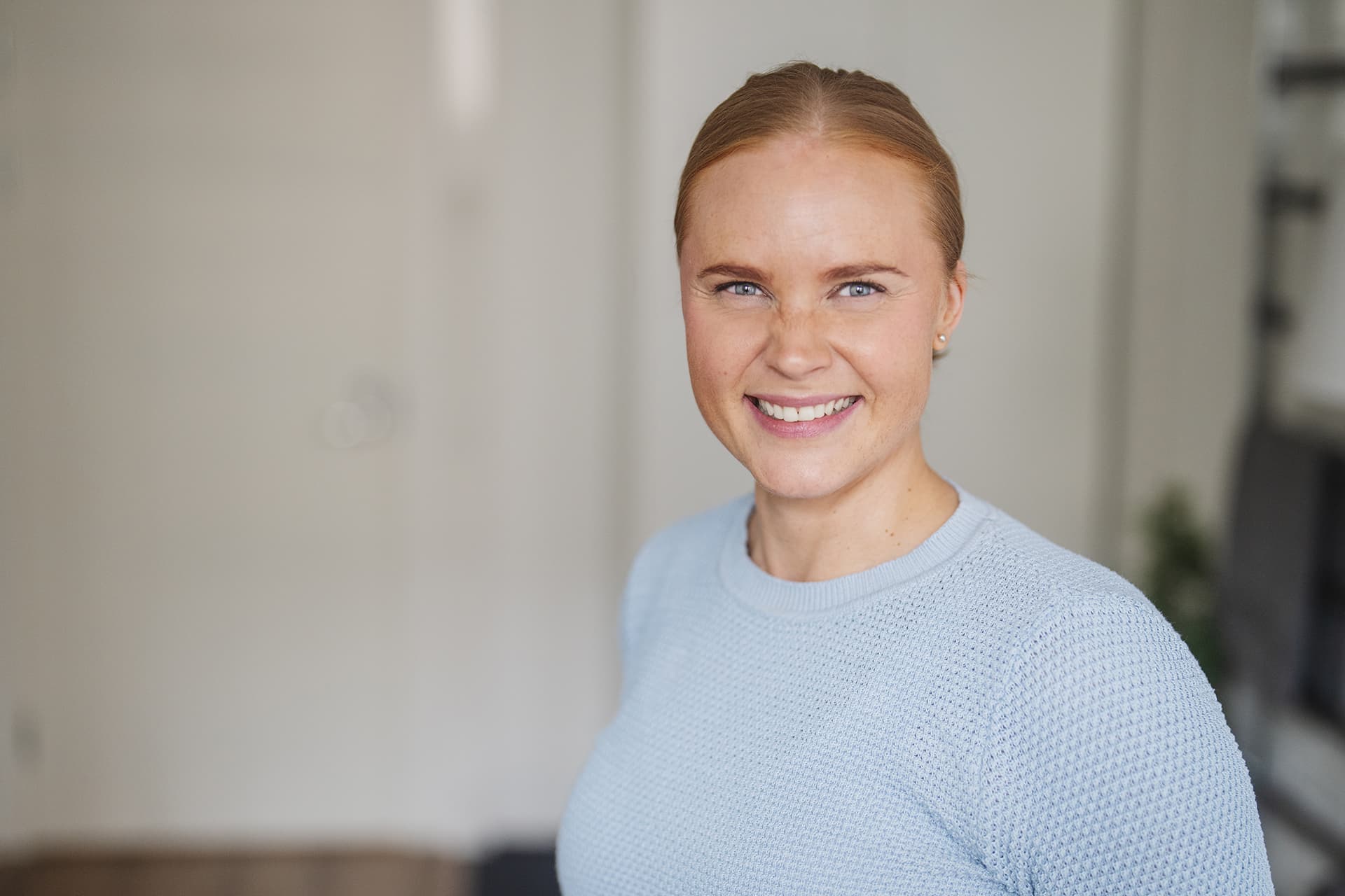 Mehiläisen fysioterapeutti Minna hymyilee iloisena kuntoutussalissa.