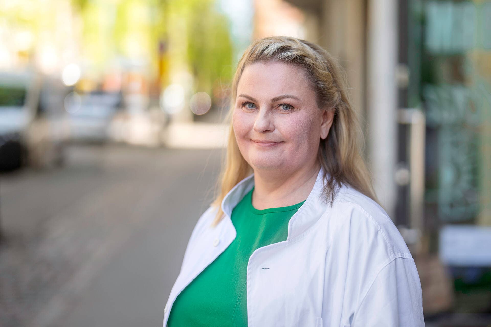 Gynekologi seisoo lääkärikeskuksen edessä kadulla.