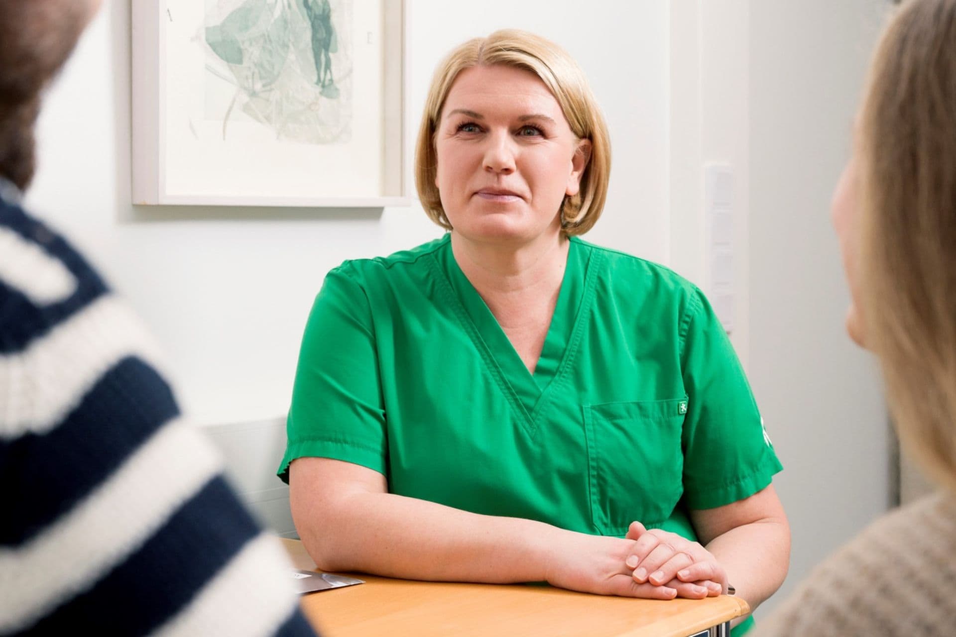 Lapsettomuushoitaja keskustelee asiakkaiden kanssa Felicitas Mehiläisen vastaanotolla.