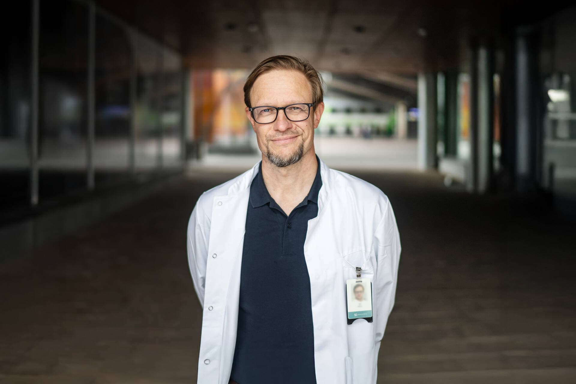 Läkaren Jyri står utomhus och tittar in i kameran.