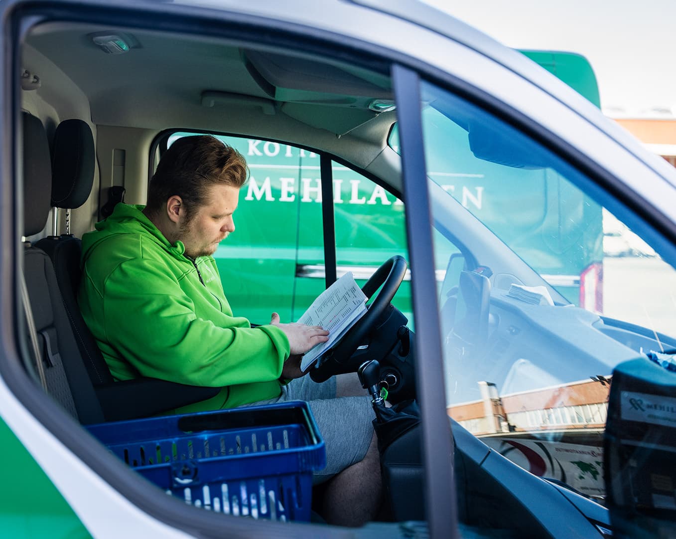 Mies istuu pakettiautossa