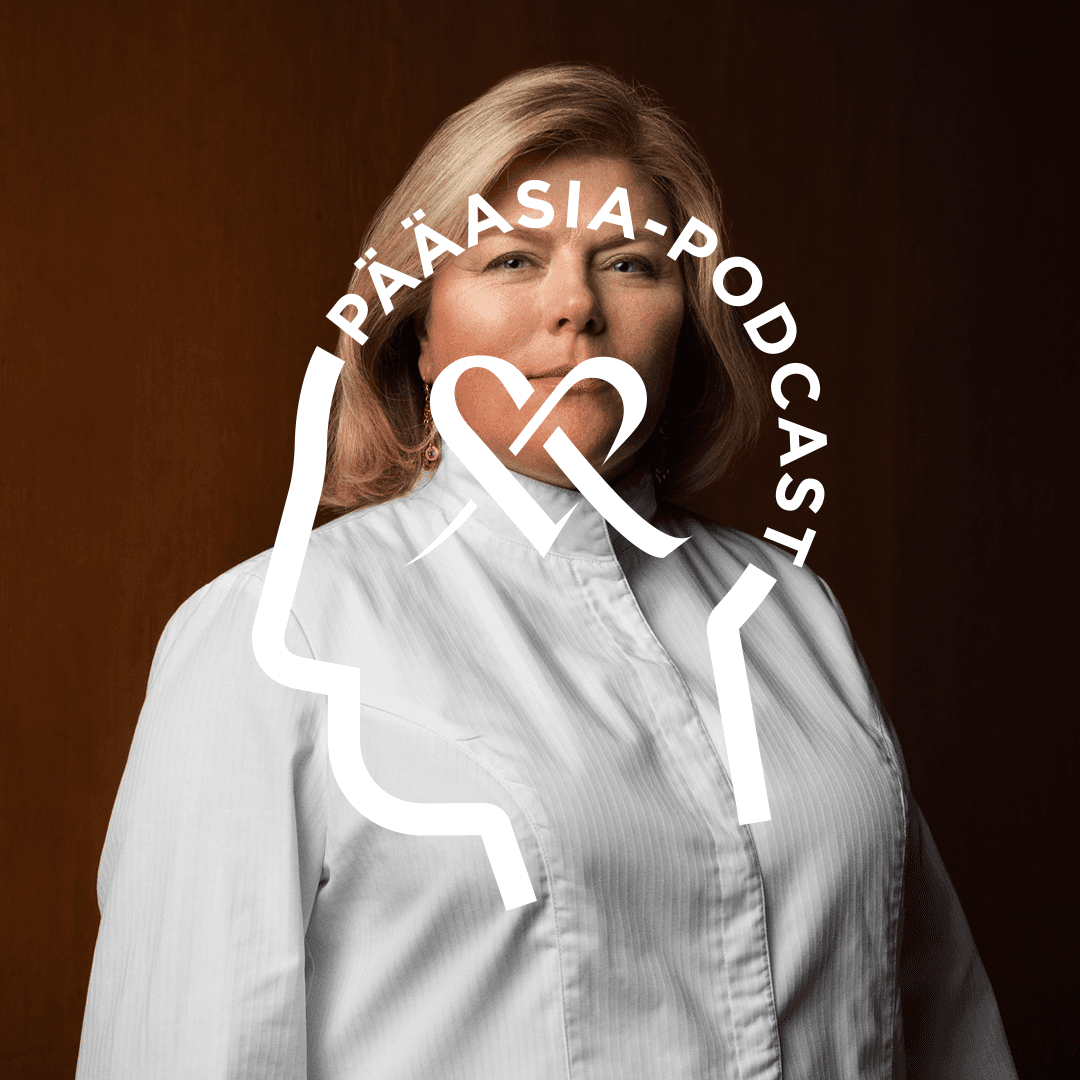 Helena Puolakka poserar för kameran i en närbild. Ovanpå bilden syns logotypen för Pääasia Podcast, där texten är formad som ett människohuvud och Mehiläinens hjärta finns i mitten av logotypen.