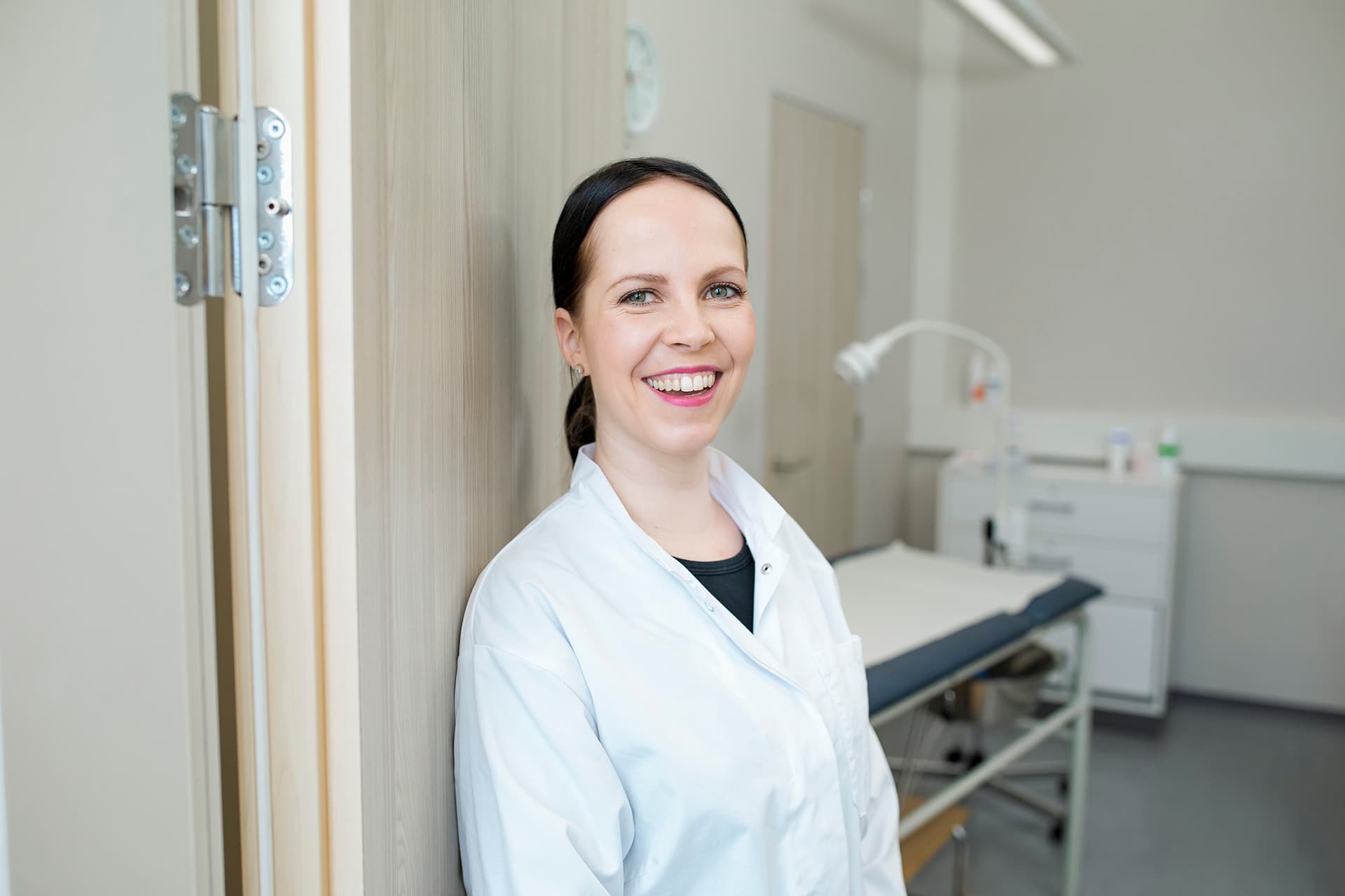 Mehiläisen gynekologi Sonja hymyilee vastaanottohuoneensa ovella.
