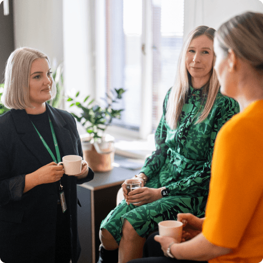 Three women having a discussion at a workplace