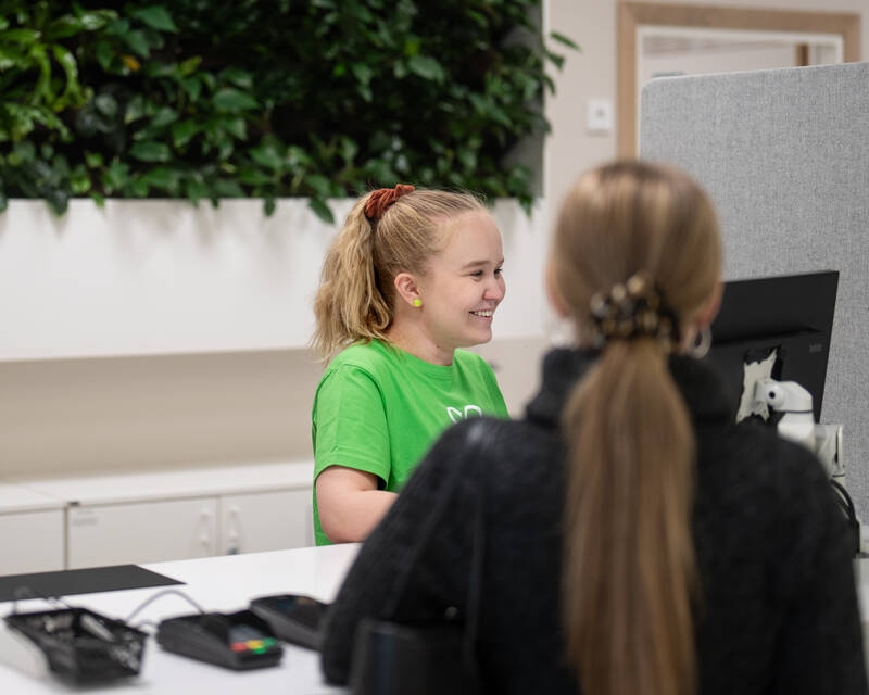 Mehiläisen palveluneuvoja Saara auttaa asiakasta asiakaspalvelupisteellä.