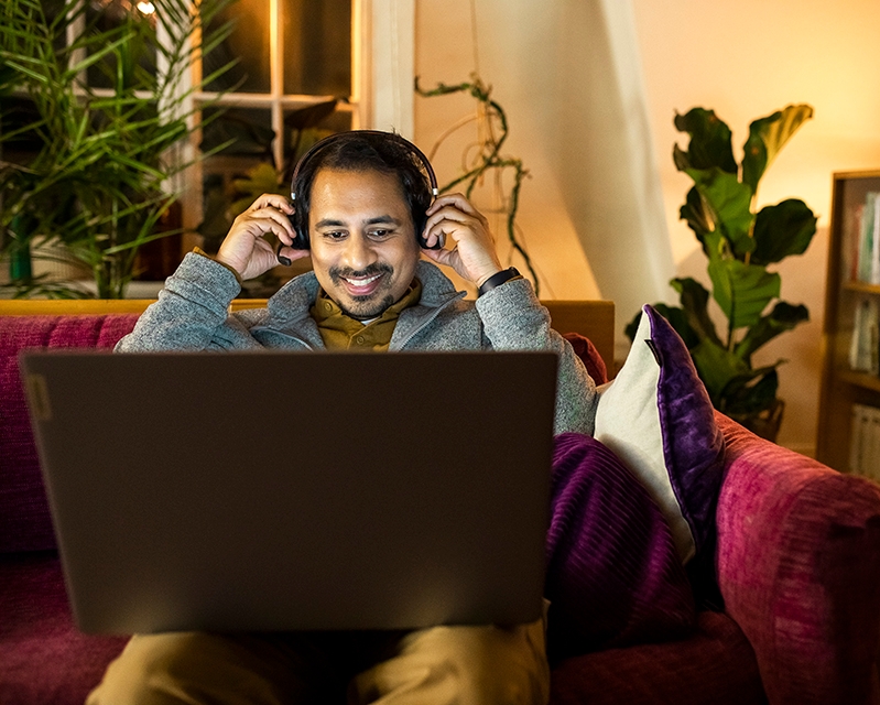 Mehiläisen Digiklinikan asiantuntija istuu sohvalla kannetta sylissä.