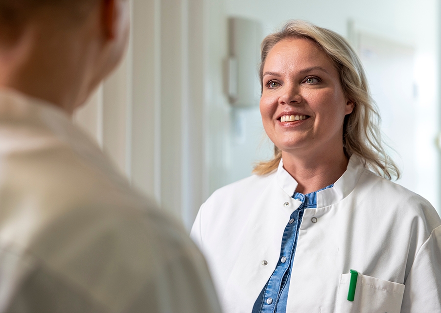 Mehiläisen lääkäri Hannele keskustelee asiakkaan kanssa vastaanottohuoneen edessä.