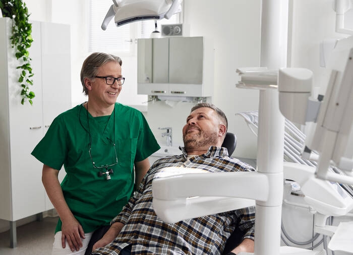 Hammaslääkäri ja asiakas hoitohuoneessa