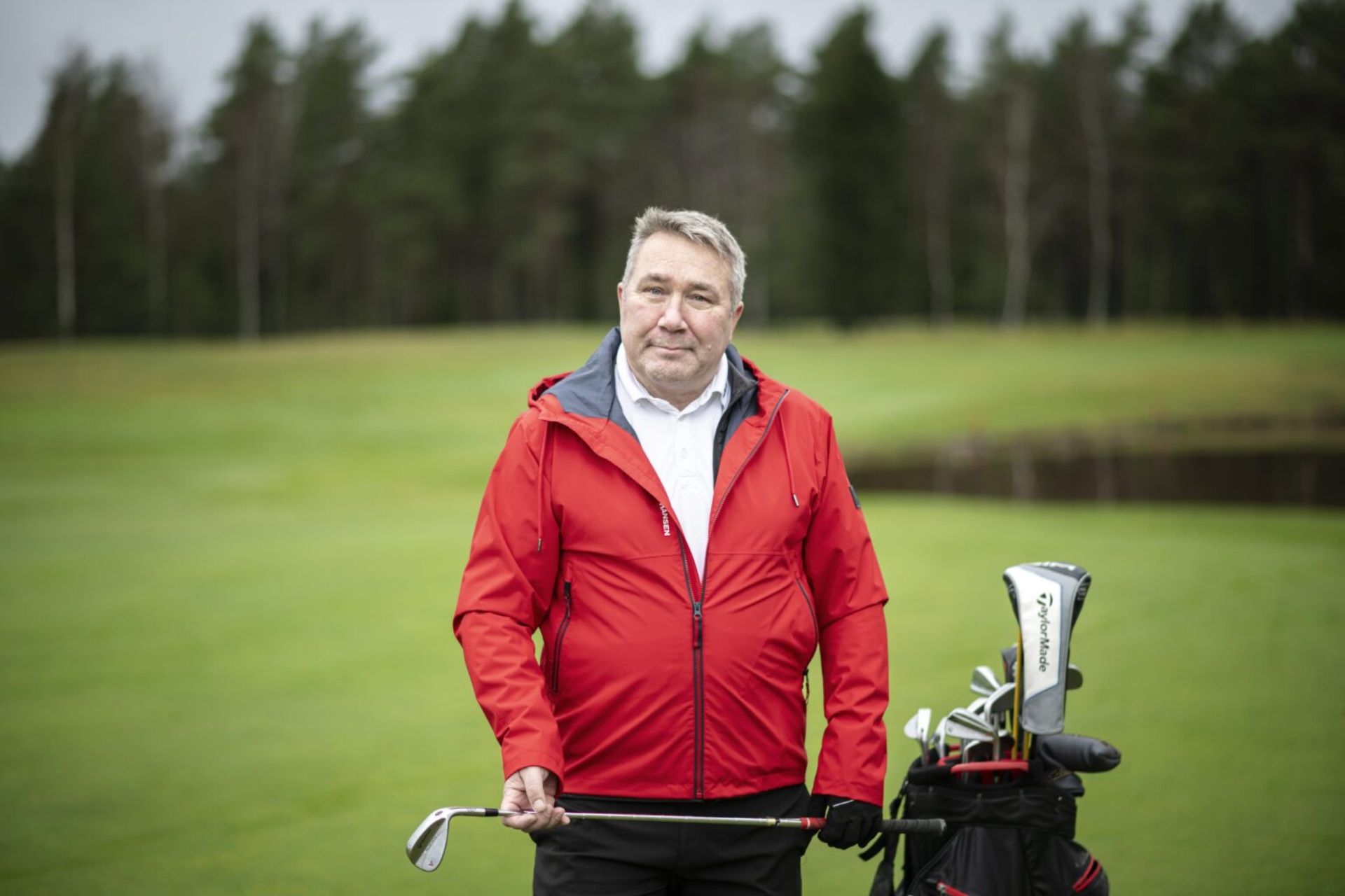 Mies punainen takki päällä seisomassa golkentällä onnistuneesta selkäleikkauksesta toipuneena.