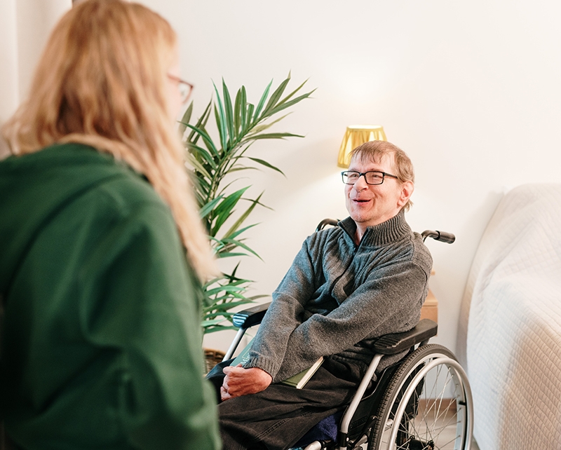 Asiakas hymyilee iloisesti Mehiläisen Kotipalveluiden henkilökohtaiselle asiakkaalle.