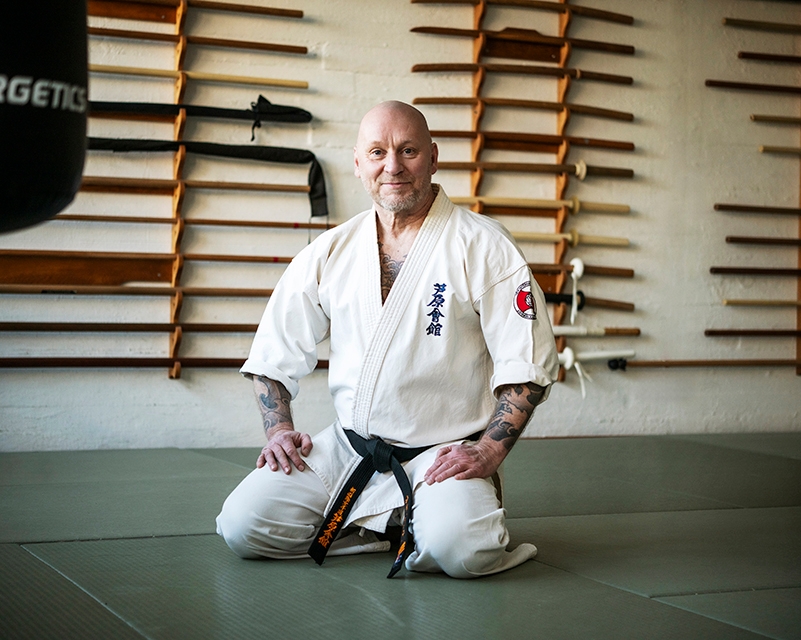 Sami Sallinen istuu kyykyssä kuntoilusalin lattialla.