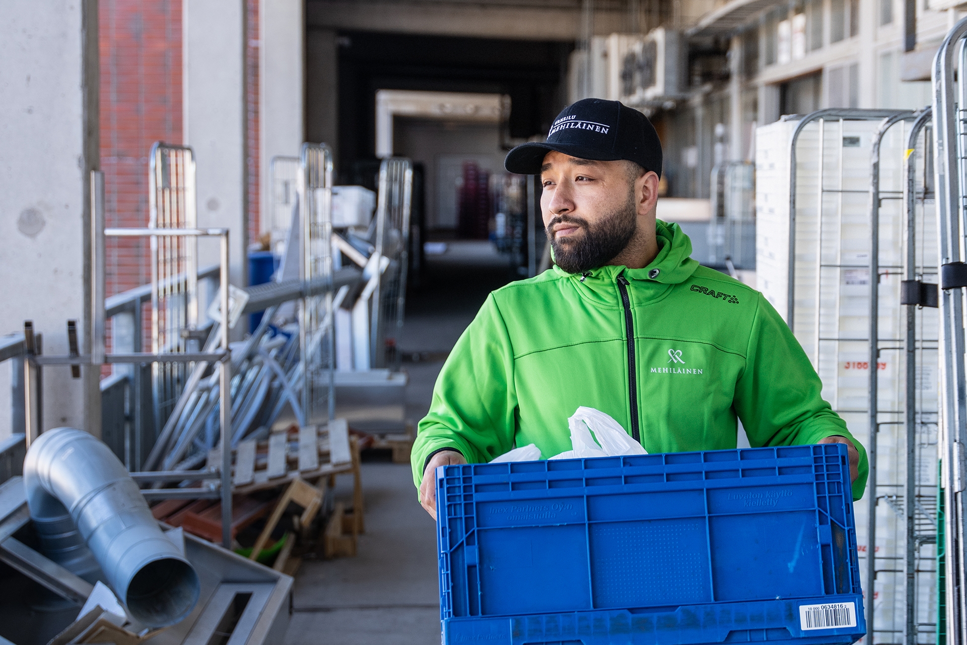 Mehiläisen ateriapalveluiden työntekijä Suleyman kantamassa ruokatarvikkeita jakeluautoon.